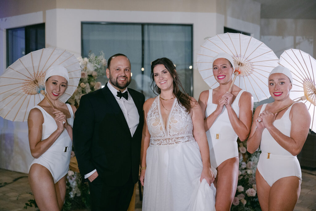 Couple enjoying their wedding reception with the synchronized swimmers who performed at their destination wedding in Palm Springs