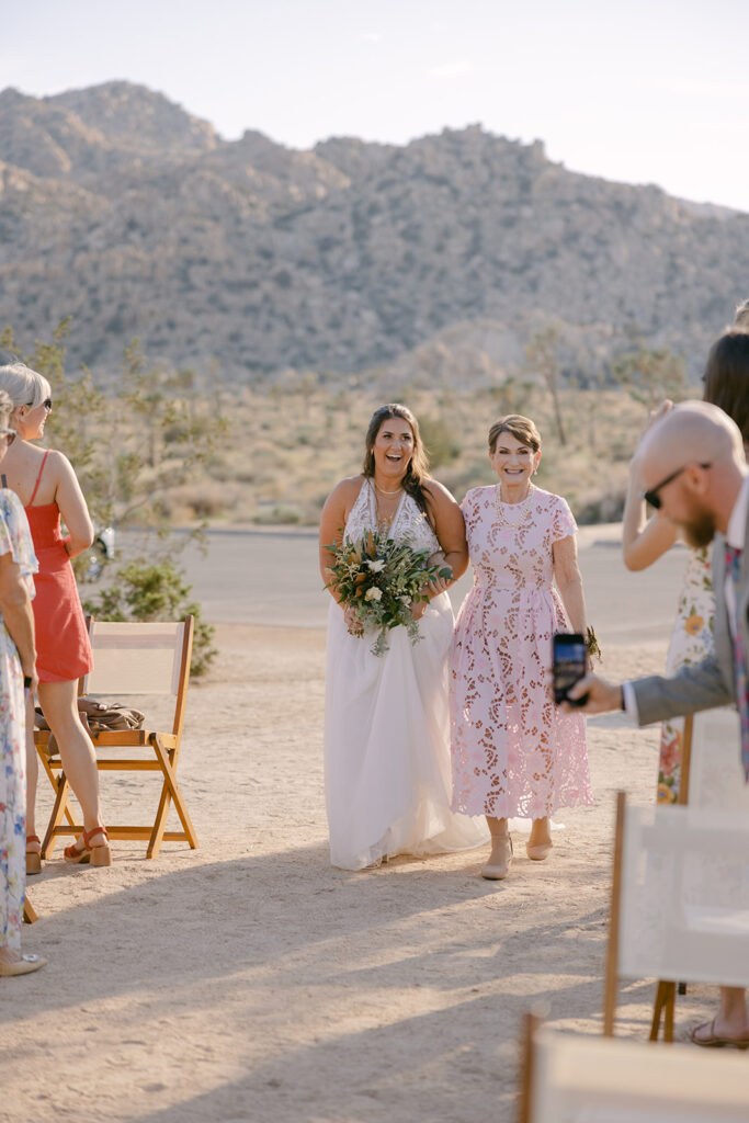 Bride + mother walking down the aisle during ceremony in Joshua Tree