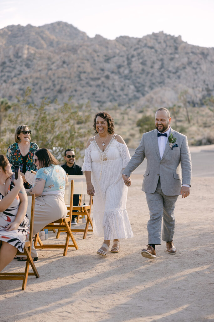 Groom + mother walking down the aisle during ceremony in Joshua Tree