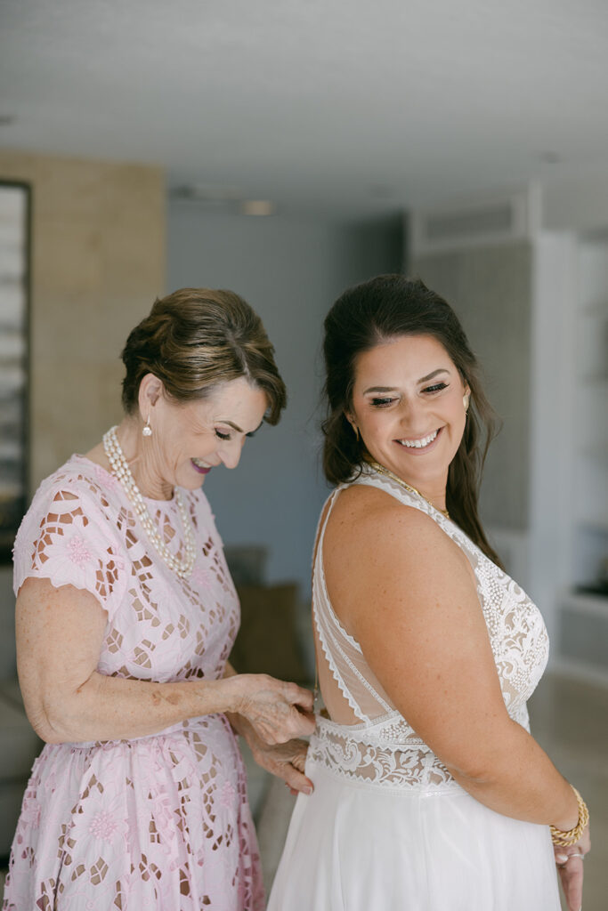 Bride having her mother get her into her wedding dress in Palm Springs